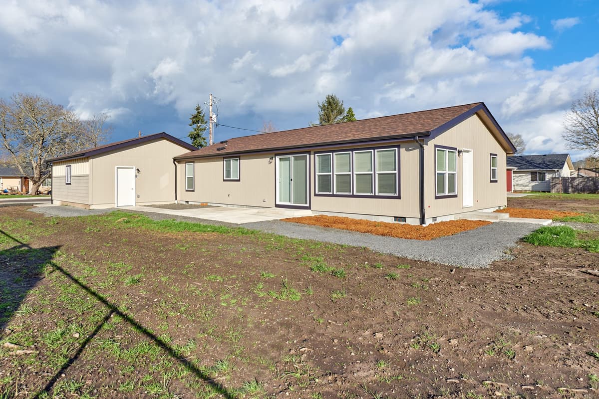 Left side of manufactured home with a patio area and garage.